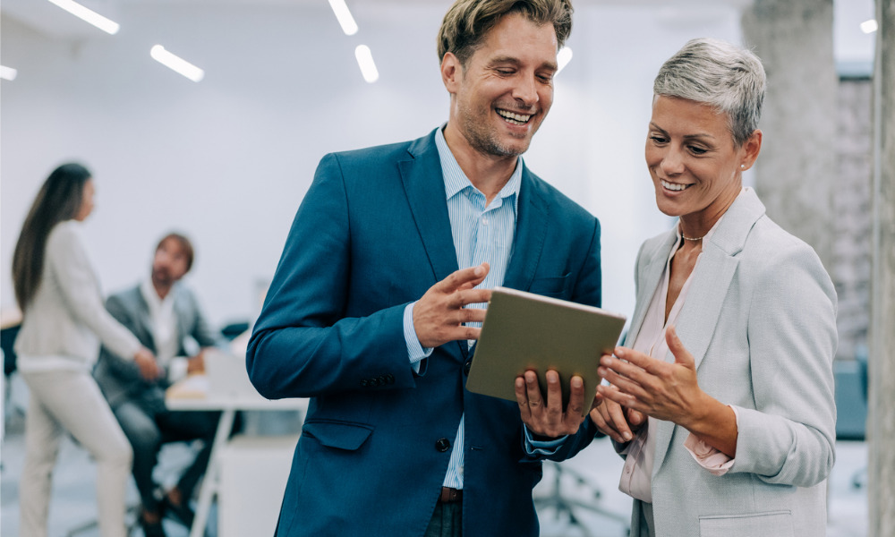 Two colleagues looking over a shortlist on a tablet in an office
