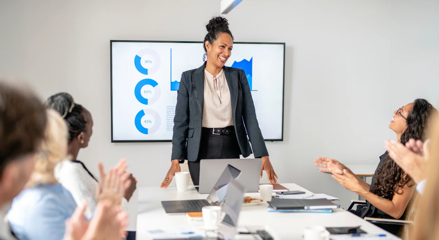Colleagues applauding a team member during a presentation
